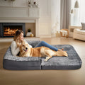 Woman and dog lying on a large pet bed in a cozy living room.