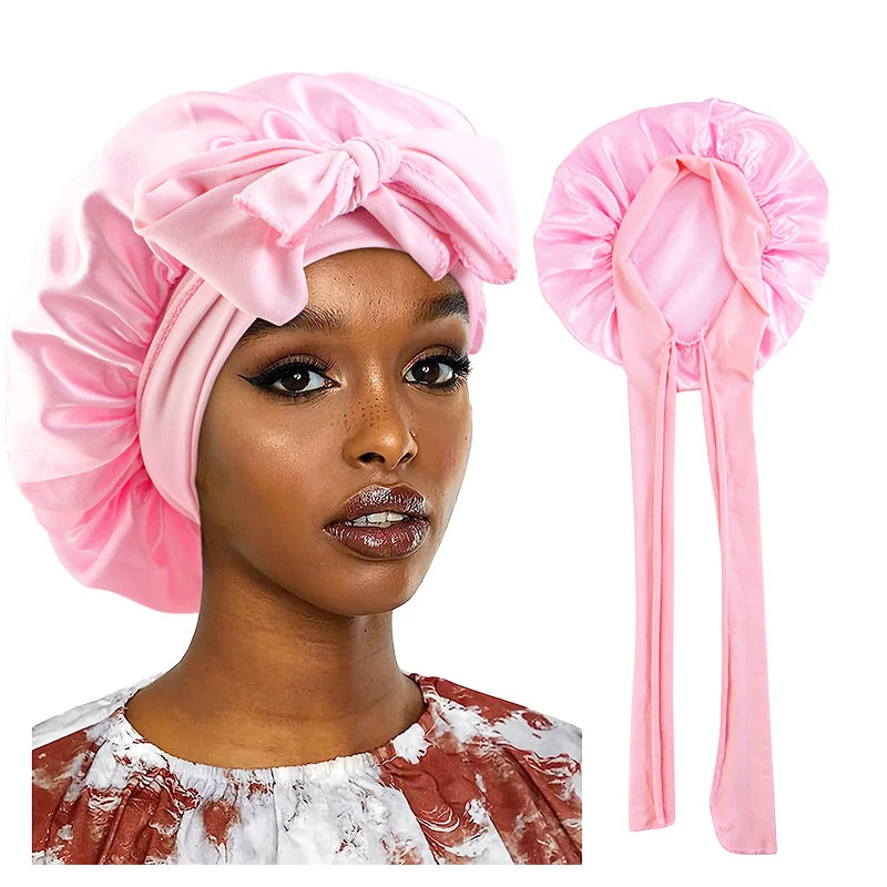 A pink satin bonnet-style headwrap shown on a model and as a standalone product against a white background.