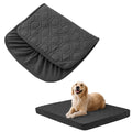 Dog lying on a black quilted pet bed with a matching cover on a white background