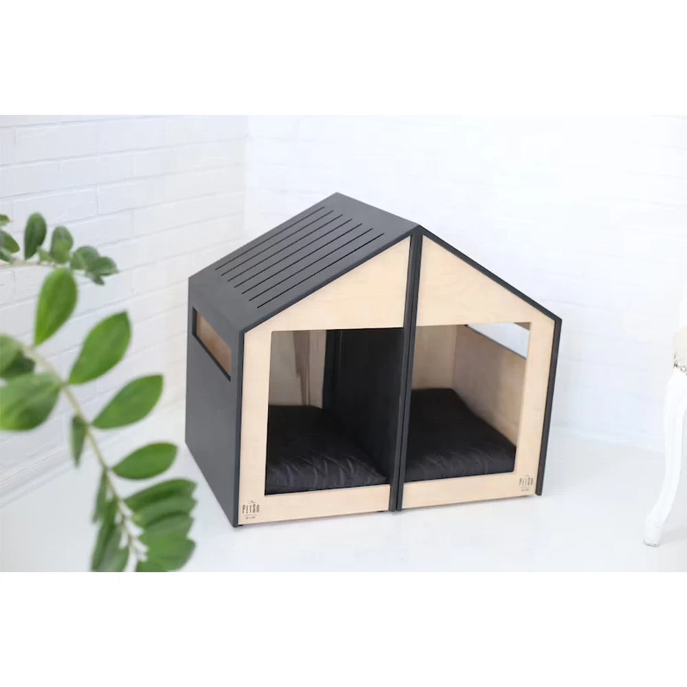 Black and wooden pet house on a white background with a plant on the side.