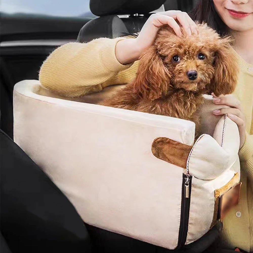 Small brown dog in a beige pet carrier held by a person inside a vehicle.