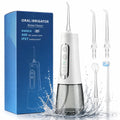 A white and clear oral irrigator water flosser with multiple nozzle tips and a cleaning head, shown next to its blue retail box on a white background with water splash graphics.