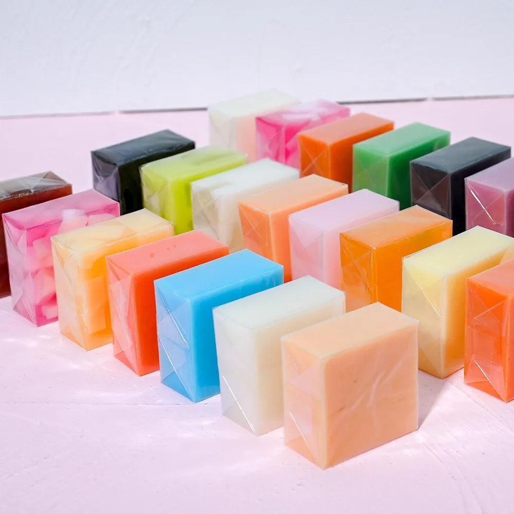 Assorted colorful soap bars on a light pink background