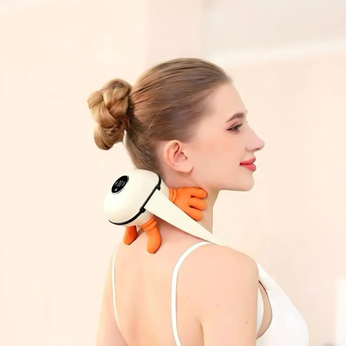 Woman using an orange and white neck massager against a plain background